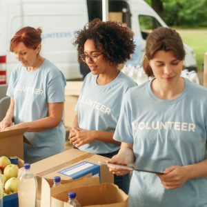 Group of Volunteers Preparing Free Food Rations for Poor People in Need. Charity Workers and Members of the Community Work Together. Concept of Giving, Humanitarian Aid and Society.